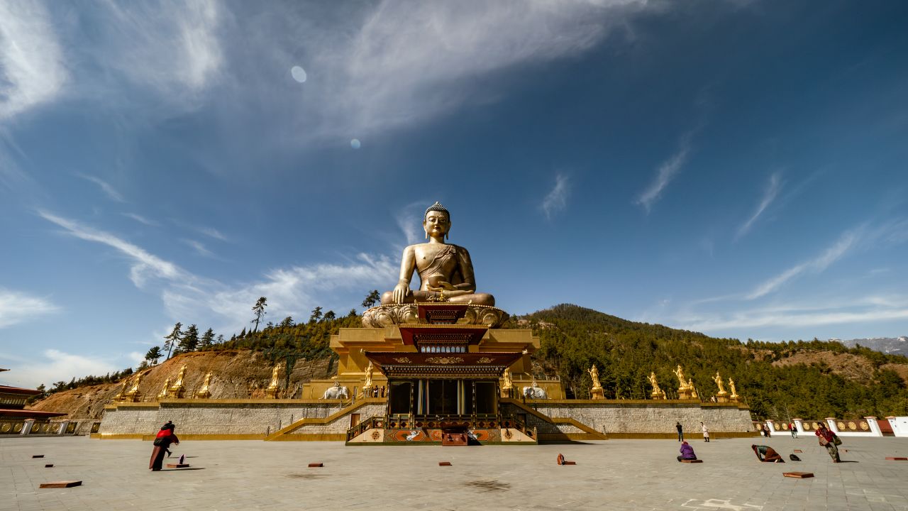 Buddha Dordenma statue overlooking Thimphu with people worshipping below