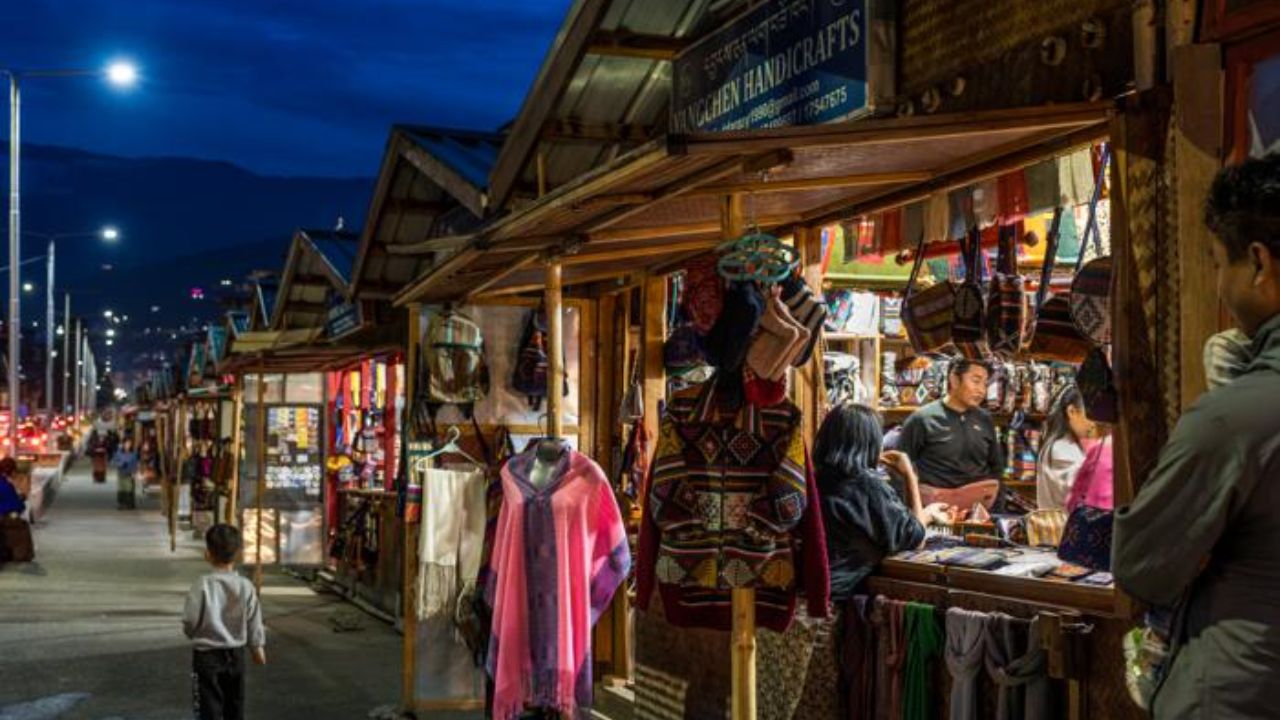 Evening street market in Bhutan with colorful handicraft stalls and local shoppers.