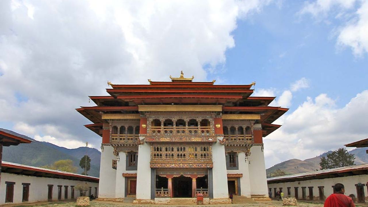 Ornate monastery with a monk walking in the courtyard.